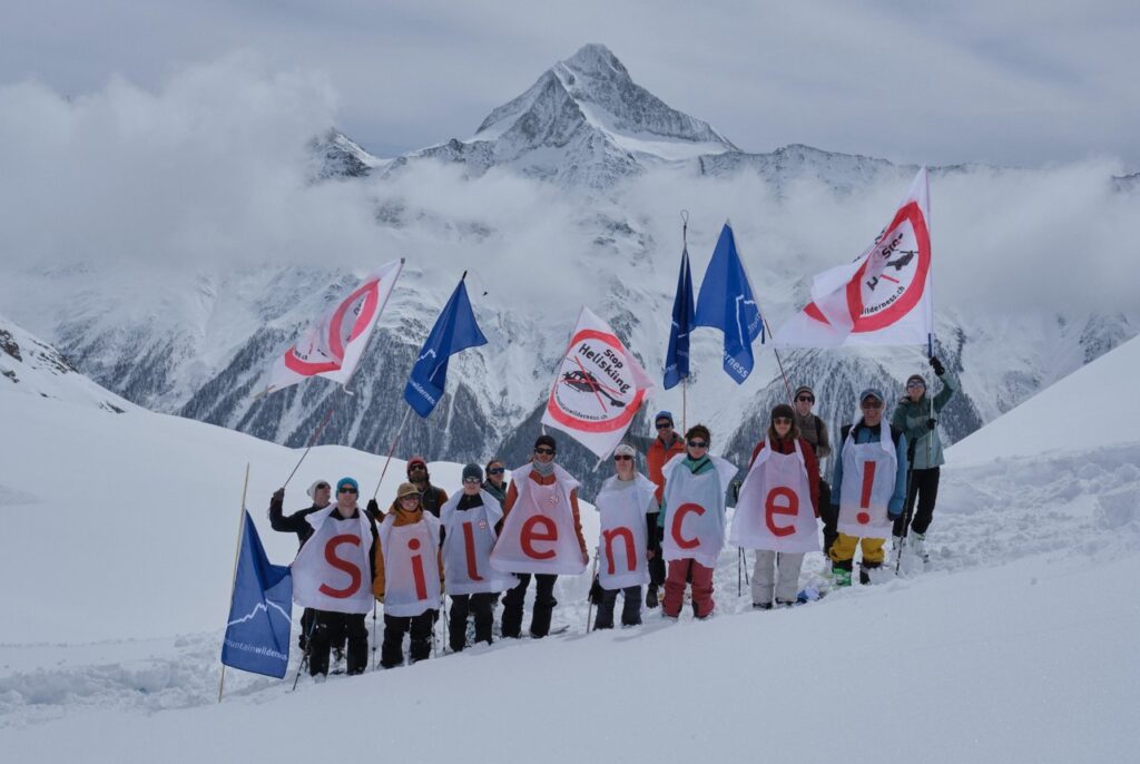 Des activistes de Mountain Wilderness Suisse manifestent le 14 avril sous la place d'atterrissage en montagne du Petersgrat (3'131 m) contre l'héliski et les autres activités aériennes de loisir en haute montagne. © Mountain Wilderness/Niklas Eschenmoser.