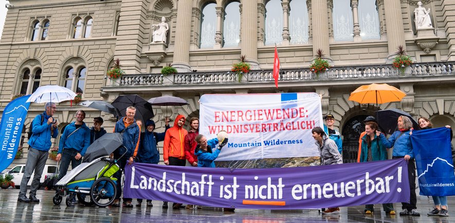 Aktivist:innen von Mountain Wilderness Schweiz setzen ein sichtbares Zeichen für eine wildnisverträgliche Energiewende vor dem Bundeshaus. ©Gianni Corona